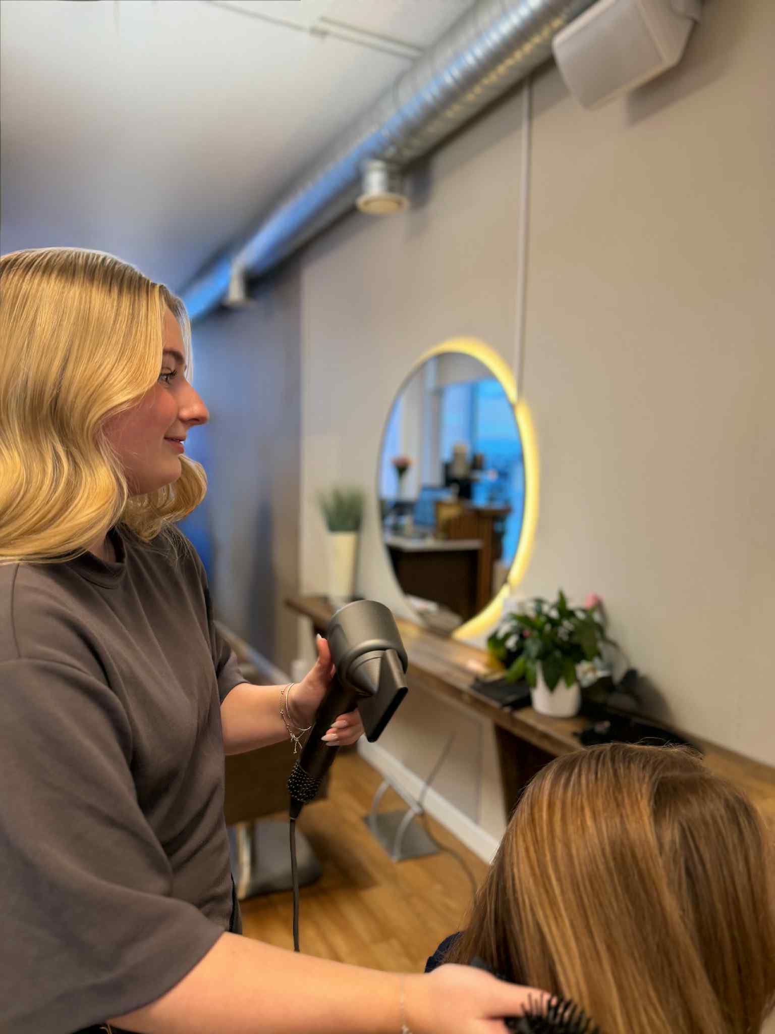 Frisör föhnar kunds hår på Clive Russel salong